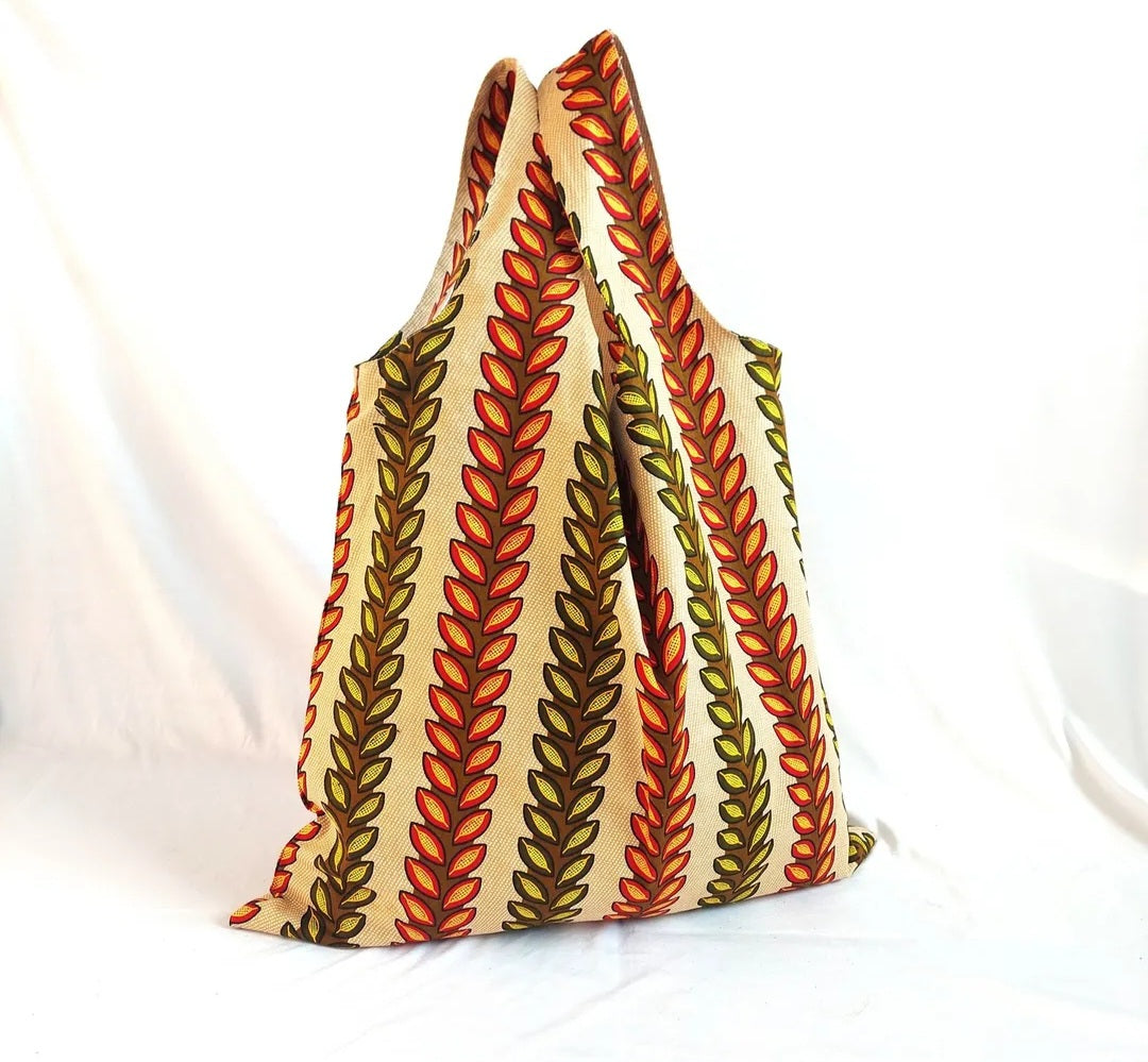 A reusable shopping bag from the brand UMA with a leafy print.
